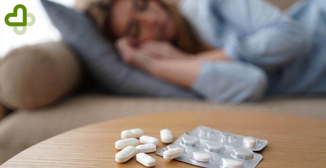 Женщина лежит на диване с таблетками