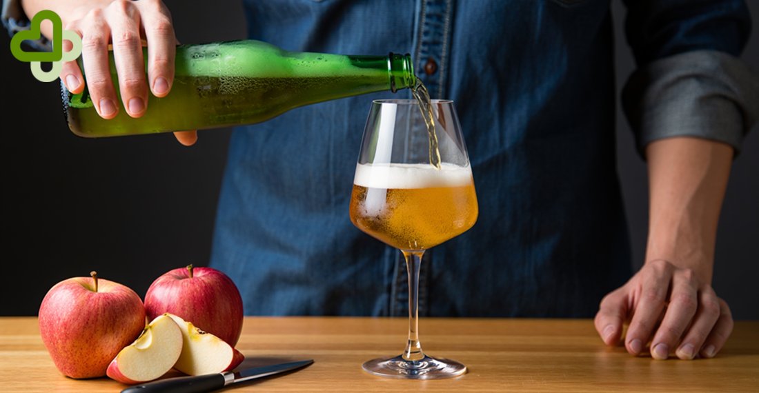 Мужчина наливает сидр в бокал