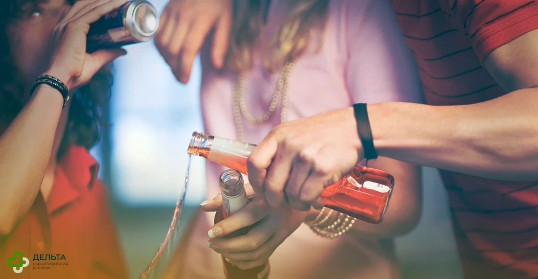 Подростки чокаются напитками в бутылках